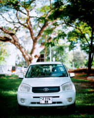 White Toyota RAV4 parked on grass under trees